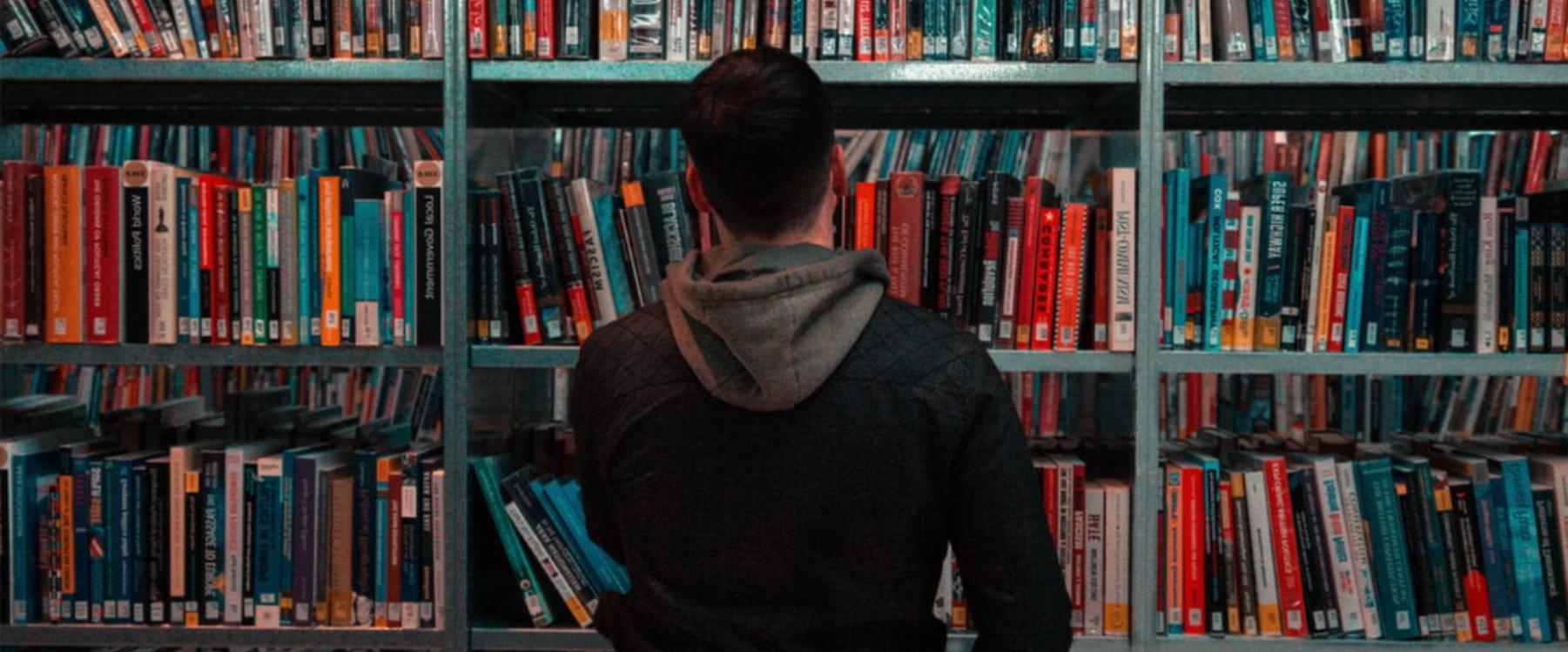 Student looking at books on a shelf